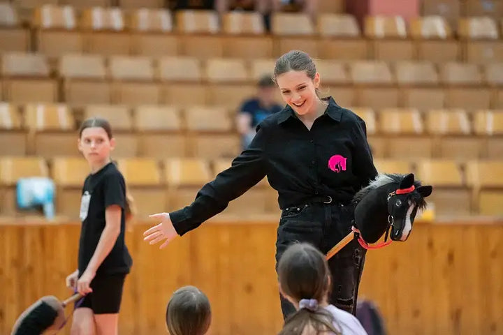 Démonstration de Hobby Horsing dans une salle de sport avec une femme tenant un Hobby Horse noir