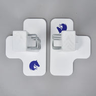 Deux obstacles Jump 50 cm / 20 inch blancs en forme de croix de Hobby Horse LarDen, chacun avec un logo de tête de cheval bleu et un support métallique central, face à face sur une surface grise, idéal comme obstacle de Hobby Horsing à hauteur réglable en intérieur ou en extérieur.