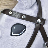 Gros plan du visage d’un cheval en peluche avec œil noir et blanc cousu, fourrure gris clair, et Bride complète marron avec diamants en similicuir de Hobby Horse LarDen.