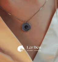 A close-up shows a person wearing the Hobby Horse LarDen silver necklace with a round 925 sterling silver pendant engraved with a horse head and "LarDen," featuring the brand logo and name, showcasing passion for Hobby Horsing.