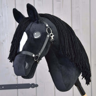 Hobby Horse Cloony avec licol noir de Hobby Horse LarDen, étalon American Quarter Horse en peluche avec tissu noir, tache blanche sur le visage, yeux en bouton, crinière noire en fil et bride sur fond en bois clair.