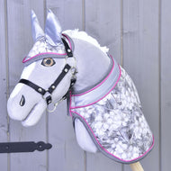 Ensemble Fleur Grise de Hobby Horse LarDen avec Hobby Horse en peluche gris, bride noire, harnachement argenté et rose, motif floral et couverture assortie, sur fond en bois gris clair.