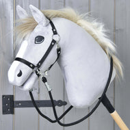Hobby Horse - Rênes noires de Hobby Horse LarDen, avec tête grise en peluche, bride noire, rênes en paracorde et crinière blanche sur un bâton en bois, présenté devant des panneaux en bois gris avec une charnière métallique noire visible.