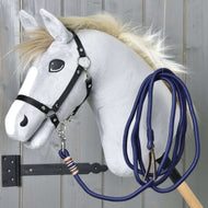 Hobby Horse - Corde de longe de Hobby Horse LarDen avec cheval gris à crinière duveteuse, yeux façon dessin animé, bride noire et longe bleue sur bâton en bois, présenté devant un mur en bois gris.