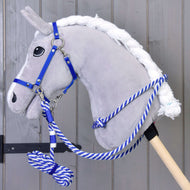 Ensemble Départ bleu (licol, longe, rênes, cordeo) de Hobby Horse LarDen, présenté sur un Hobby Horse en peluche grise avec une longe bleue et blanche sur un bâton en bois, devant un mur en bois gris.