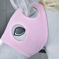Gros plan sur un cheval en peluche gris portant le « Masque de cheval sans oreilles Rose » de Hobby Horse LarDen, un masque lavable avec un œil brodé et des ouvertures pour les oreilles. Des panneaux en bois sont visibles en arrière-plan.