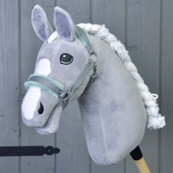 Licol gris avec fourrure menthe de Hobby Horse LarDen, accessoire pour Hobby Horse gris en peluche avec crinière blanche et marques sur le visage, sur fond en bois gris.