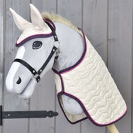 Ensemble Suprême Crème de Hobby Horse LarDen avec Hobby Horse en peluche au visage gris, museau et oreilles blancs, habillé d'une couverture matelassée crème et d'un bonnet d'oreilles assorti à bordure violette, présenté sur un mur en bois.