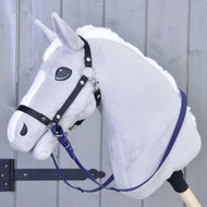 Rênes caoutchoutées violet foncé de Hobby Horse LarDen sur un Hobby Horse gris en peluche avec bride noire, crinière blanche et bâton en bois, en gros plan devant un fond en bois gris clair.