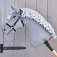 The Hobby Horse Grace with Black Halter by Hobby Horse LarDen is a gray Dutch Warmblood with a yarn mane, mounted on a wooden stick and shown against a wooden panel wall.