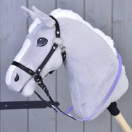 Hobby Horse en peluche grise de Hobby Horse LarDen avec crinière blanche, bride sans mors et rênes caoutchoutées violet clair, monté sur un bâton en bois devant un fond en bois à panneaux.