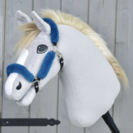 Hobby Horse LarDen Licol en fourrure Teddy pétrole, un Hobby Horse en peluche avec tissu gris clair, museau blanc, crinière blonde et licol bleu en similicuir sur un bâton noir, présenté devant un fond en bois.