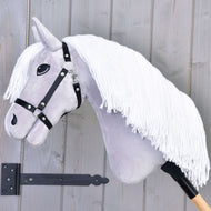 Hobby Horse Popcorn avec licol noir de Hobby Horse LarDen, avec tissu gris, longue crinière blanche en fil et licol noir sur un bâton en bois, présenté devant un mur en bois gris clair.