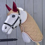 Ensemble Roma de Hobby Horse LarDen, Hobby Horse en peluche avec visage gris clair, bride noire, manteau matelassé beige et bonnet d’oreilles bordeaux, idéal pour le jeu imaginatif ou à associer à un ensemble couverture.