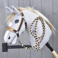 Ensemble LarDen Exclusive Brun de Hobby Horse LarDen avec Hobby Horse gris en peluche, crinière blanche, bride marron, muserolle en polaire et rênes en corde tressée sur un bâton en bois, présenté devant un mur en bois gris.