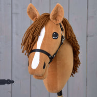 Hobby Horse Wendy avec licol noir de Hobby Horse LarDen, avec tête en peluche marron, crinière tressée en fil marron, marque blanche sur le museau et licol noir, inspiré d’une jument alezane et présenté sur fond en bois gris.