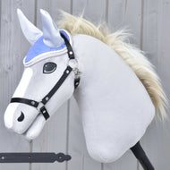 The Hobby Horse LarDen Ear Bonnet Light Violett is shown on a plush hobby horse with a light gray body, white mane, and black bridle, set against a wooden background.