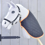 Couverture Drapeau de Hobby Horse LarDen sur un Hobby Horse gris avec bride noire et couverture matelassée à bordure orange, monté sur un bâton en bois devant une clôture en bois gris.