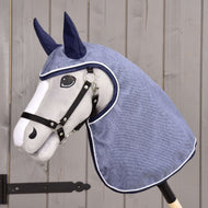 Imperméable en jean de Hobby Horse LarDen avec tête de cheval en peluche, bride noire et capuche d’imperméable bleue avec couvre-oreilles, présenté devant du bois, idéal pour le jeu imaginatif par tous les temps.