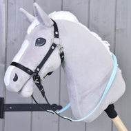 Hobby Horse en peluche grise avec crinière blanche et rênes caoutchoutées bleu clair de Hobby Horse LarDen, fixé à un bâton en bois, devant un mur en bois gris.