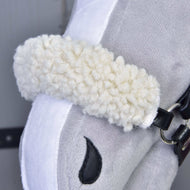 Gros plan sur l’Ensemble Harmonie Elsa de Hobby Horse LarDen, montrant sa muserolle blanche bouclée en peluche, sa bride noire en simili cuir et sa narine noire cousue sur un tissu gris et blanc doux.