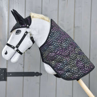 Ensemble Rêveur de Hobby Horse LarDen sur un Hobby Horse à corps blanc, avec bride noire, oreilles noires et couverture colorée à pois, présenté devant un mur en bois gris.