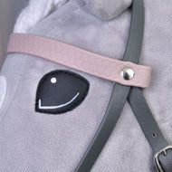 Close-up of Hobby Horse LarDen’s "Complete leatherette bridle grey with pink headband" on a plush toy horse, showing black stitched eye and detailed straps secured with a metal rivet.