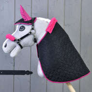 Ensemble Thermo Pinkie (bonnet d'oreilles + couverture + licol avec fourrure) de Hobby Horse LarDen, comprenant un Hobby Horse gris avec couverture noire bordée de rose, bonnet d’oreilles rose assorti et licou avec fourrure, présenté sur fond en bois.