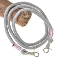 Rênes Tizian de Hobby Horse LarDen en polypropylène gris torsadé, avec mousquetons argentés et enroulements rose argenté à chaque extrémité, présentées sur du bois sur fond blanc, idéales comme rênes artisanales élégantes ou rênes pour Hobby Horse.
