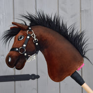 Hobby Horse Benny avec licol noir - taille XS de Hobby Horse LarDen, inspiré d’un cheval de sport belge, avec corps en peluche brun, crinière noire et licol sur un bâton en bois, présenté sur fond de panneaux en bois gris clair.