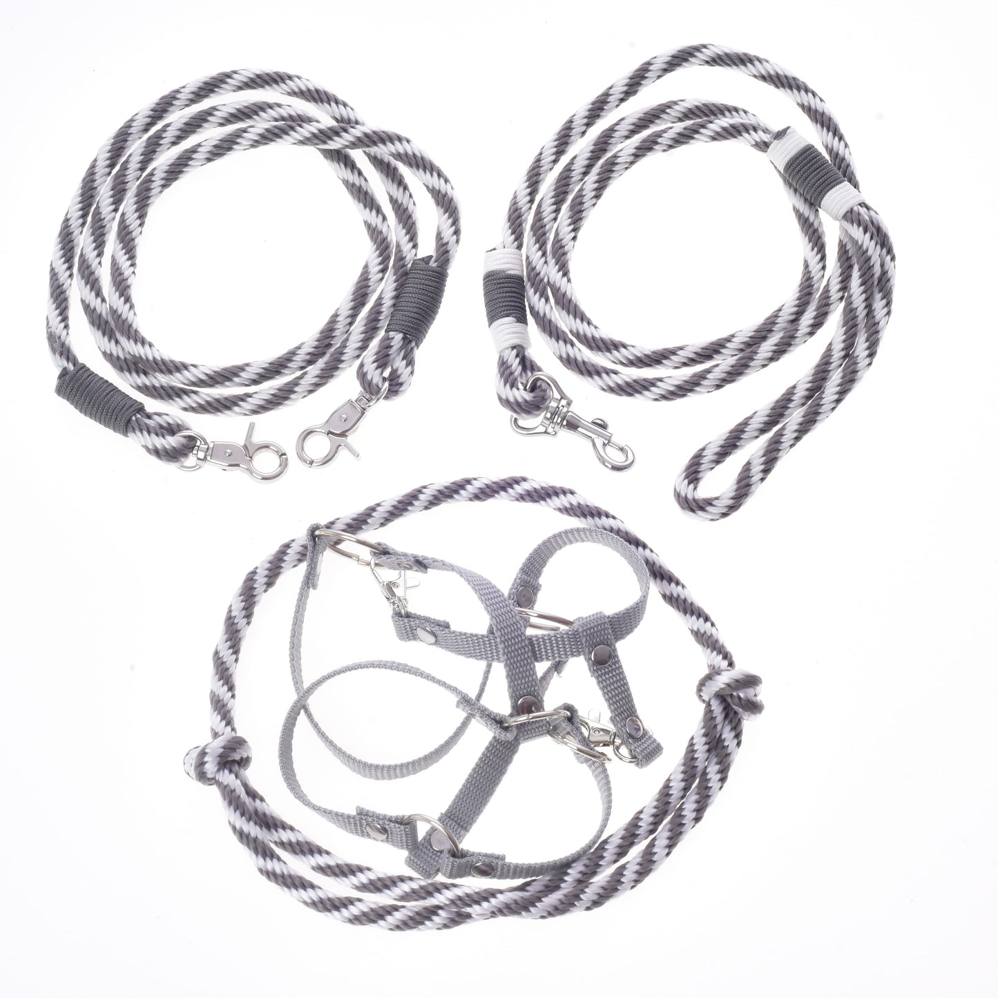 Trois accessoires rayés gris et blanc de l’Ensemble Départ Argent de Hobby Horse LarDen, comprenant un licol, une cordelette, une longe et des rênes, sont disposés sur un fond blanc. Idéal comme ensemble assorti de harnais et de longes ou de rênes pour vos accessoires Hobby Horse préférés.