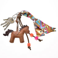 Porte-clés Horse Brown de Hobby Horse LarDen sur un porte-clés avec un jeu de clés, des perles colorées et une écharpe vive à motif nouée en nœud.