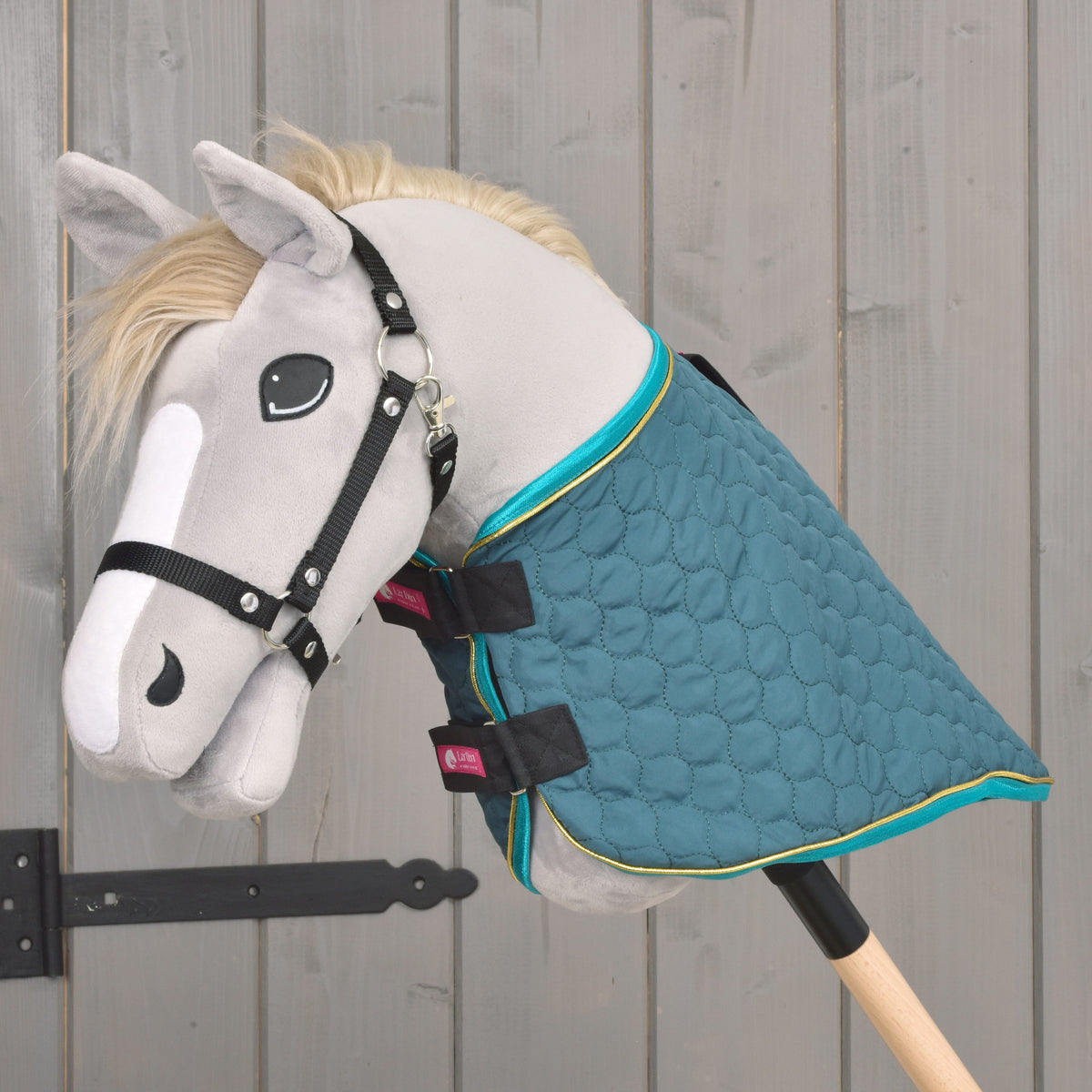 Vue de côté de la couverture Hobby Horse verte matelassée avec bordure turquoise et couvre-encolure amovible
