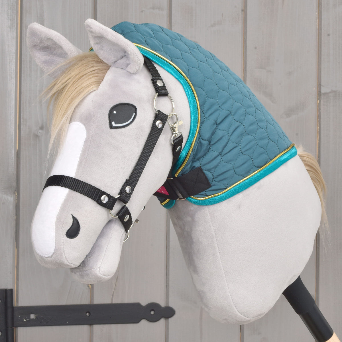 Couverture Hobby Horse verte matelassée avec couvre-encolure amovible vue de côté sur un Hobby Horse gris