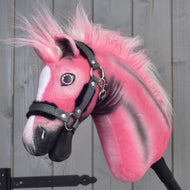 A limited edition Hobby Horse LarDen Pinkie with a glittery halter, featuring a fluffy mane and a white patch on its face, is positioned in front of gray wooden panels.