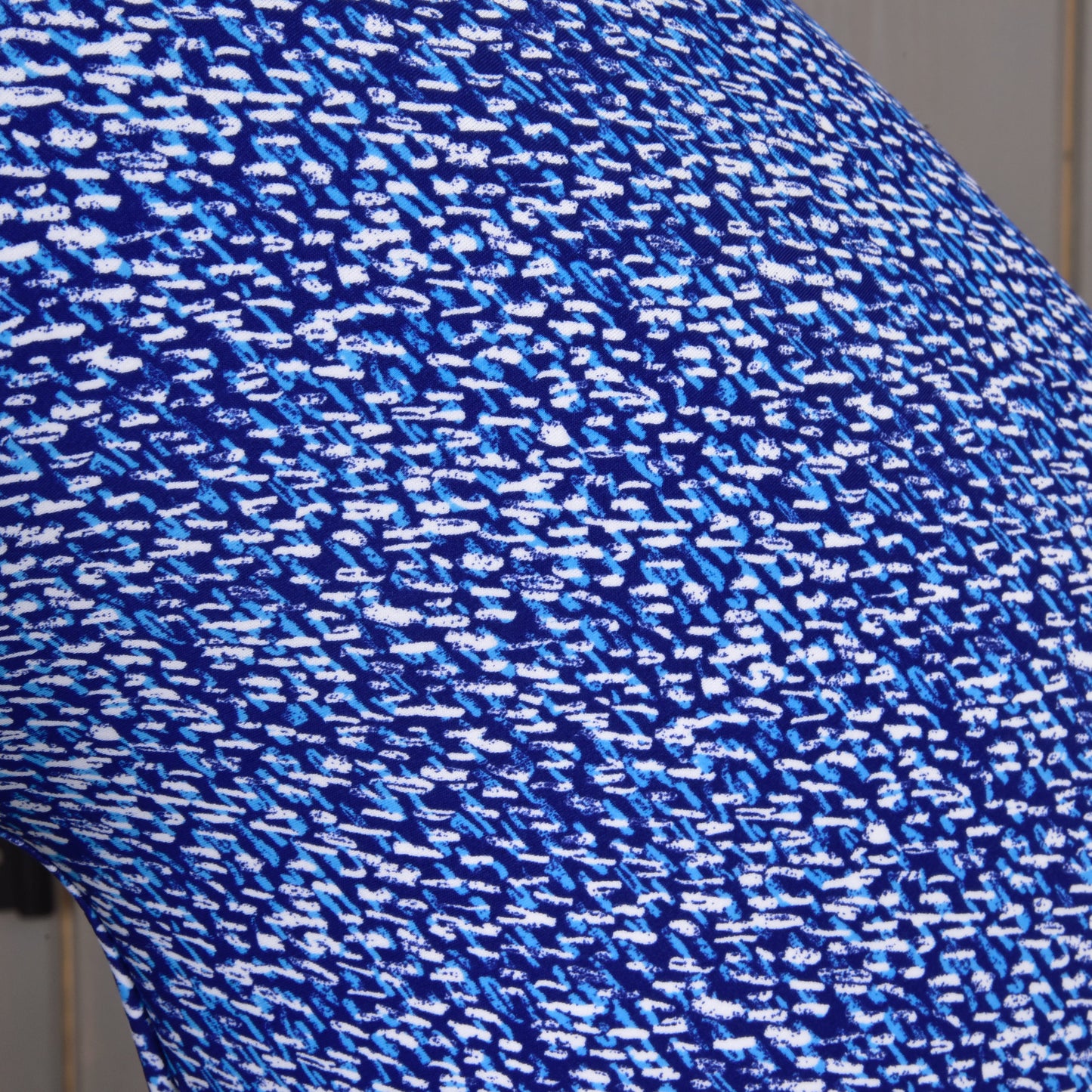 A close-up of the Hobby Horse LarDen "See" protective suit’s PES fabric, showing a blue and white abstract pattern of small, irregular dashes and spots for a dynamic, pixelated look.