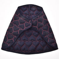 Couverture Pink Heart de Hobby Horse LarDen, cape matelassée bleu foncé avec coutures roses en forme de cœur, inspirée d'une couverture chaude pour cheval, avec ouverture frontale incurvée, sur fond blanc.