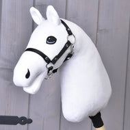 Construis ton cheval, Hobby Horse par related_to_12441055625556, avec tête blanche en peluche, yeux bleus remarquables, bride noire et rênes noires, monté sur un bâton en bois et présenté devant un mur en bois gris clair.